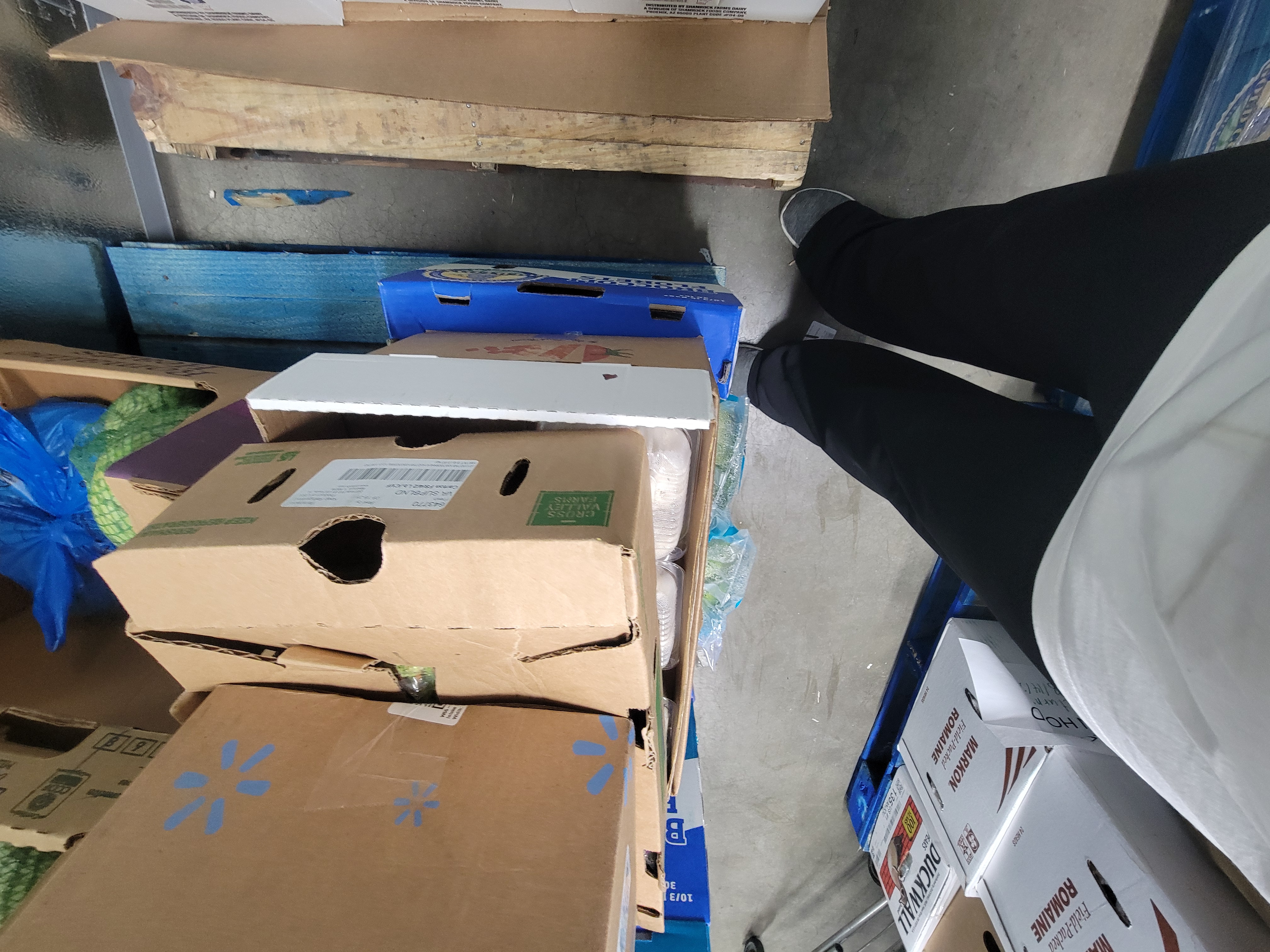 Pallets of food in a fridge box unit.